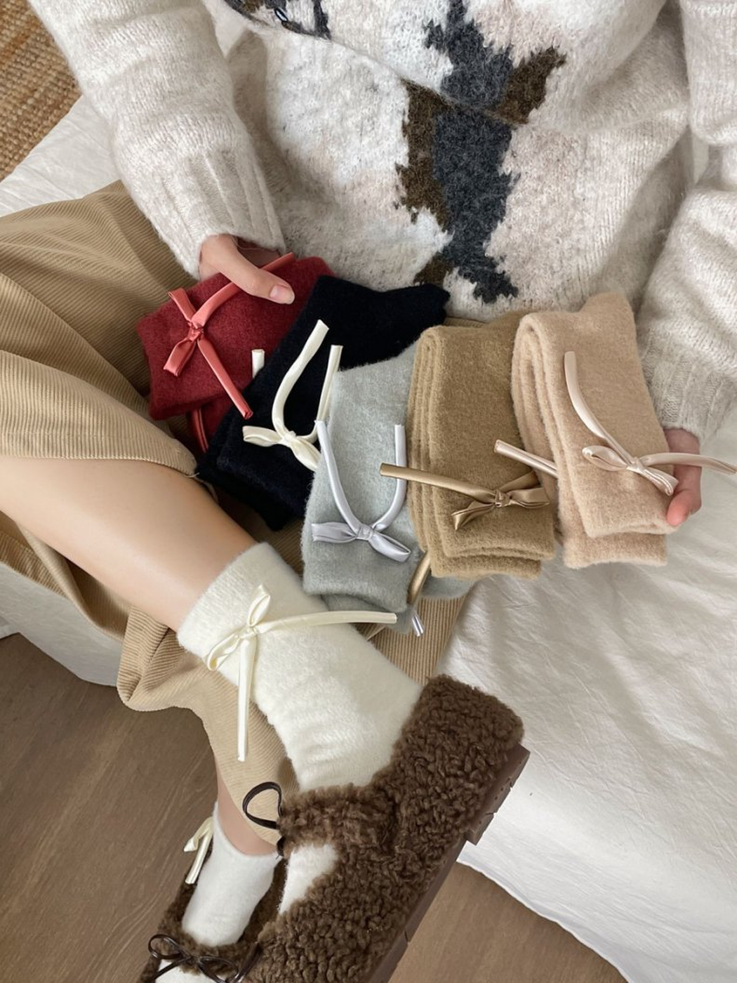 Six ribbon-bow sock colors displayed with an ivory pair worn