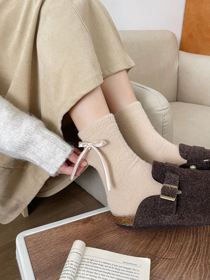 Beige ribbon-bow crew socks worn with brown buckle shoes