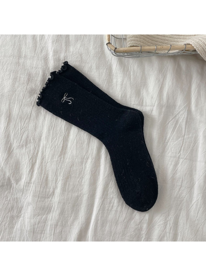 Black ribbed crew socks with bow motif and ruffled cuffs