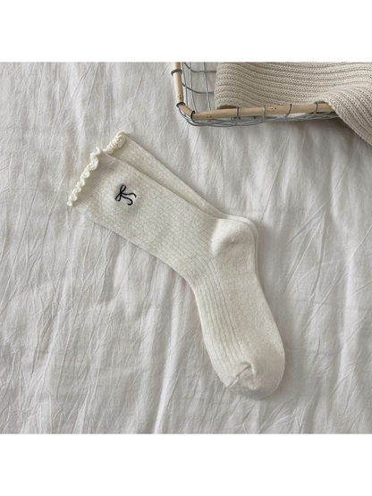 Ivory ribbed crew socks with bow motif and ruffled cuffs