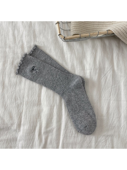 Light gray ribbed crew socks with bow motif and ruffled cuffs