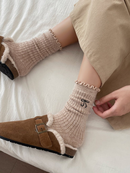 Beige ruffled crew socks worn with brown buckle shoes