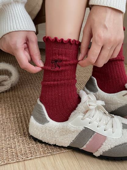 Red ribbed crew socks worn with textured lace-up shoes
