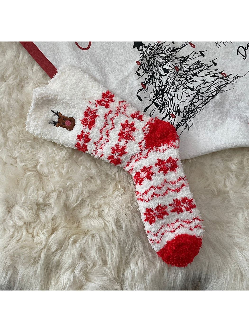 White fuzzy socks with red snowflake pattern and embroidered reindeer