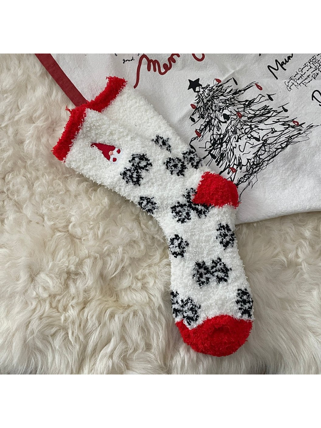 White fuzzy socks with black snowflakes and embroidered gnome