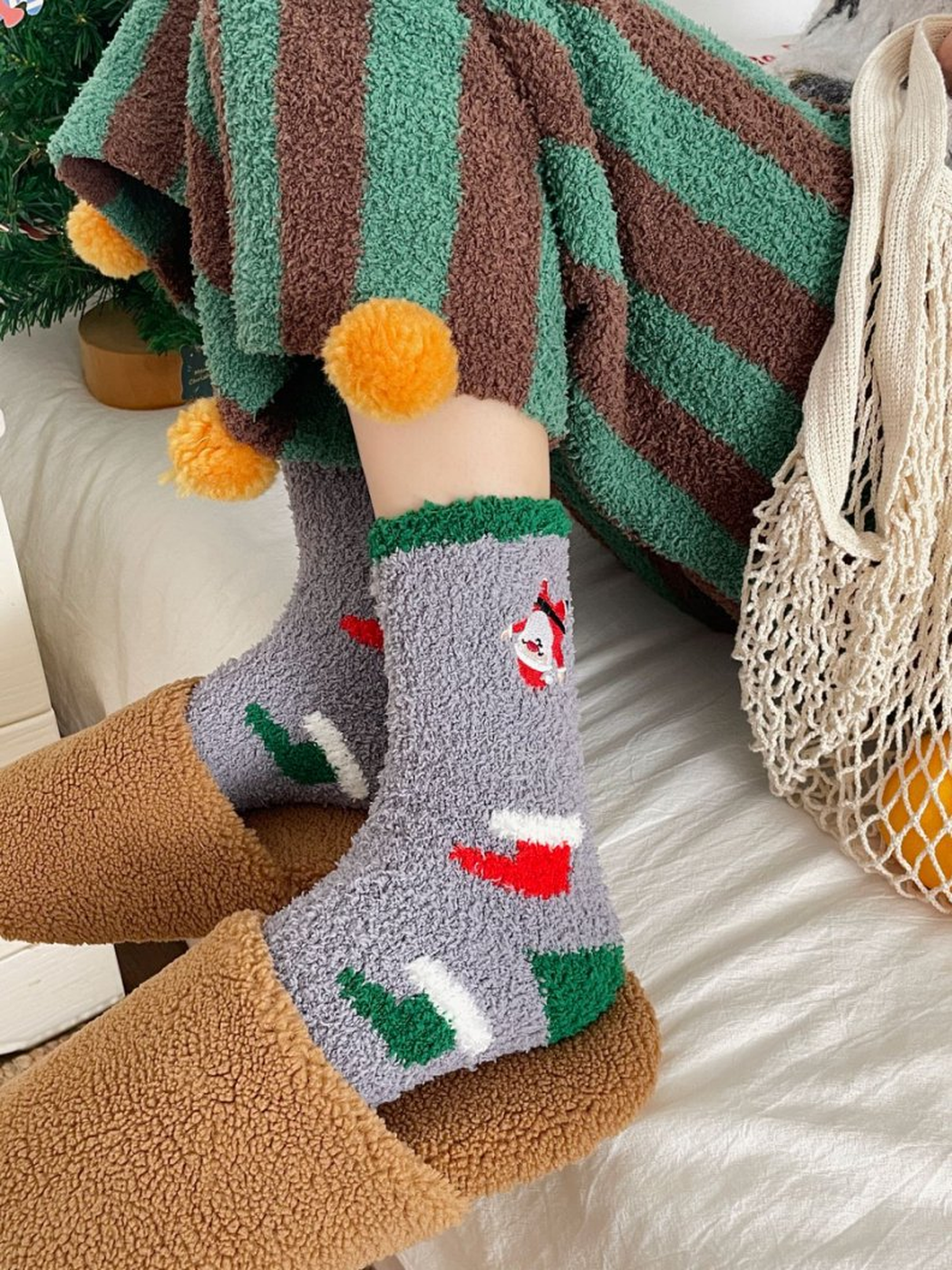Gray fuzzy Santa and stocking socks worn with brown slippers