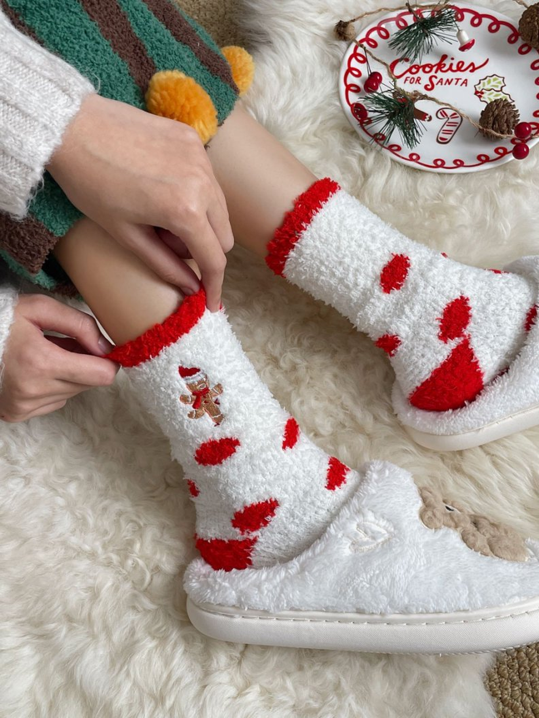 White fuzzy socks with red dots worn with white slippers