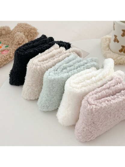 Five fuzzy sock colors folded to show their plush texture