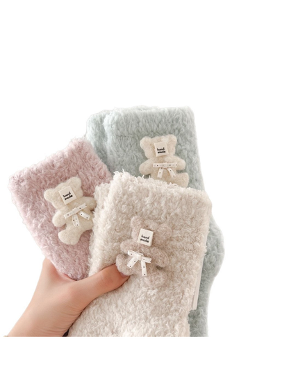 Pink, beige and pale blue fuzzy socks held together by hand