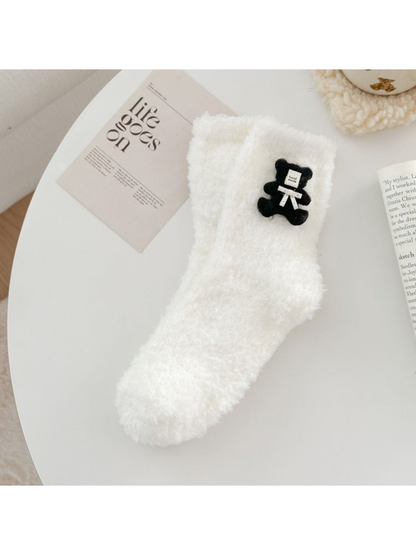 White fuzzy sock with black teddy bear applique