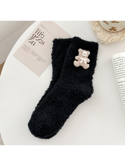 Black fuzzy sock with beige teddy bear applique