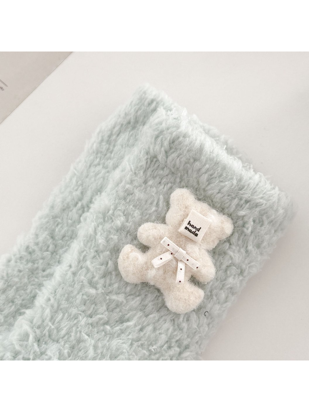 Close-up of the ivory teddy bear applique and dotted ribbon bow