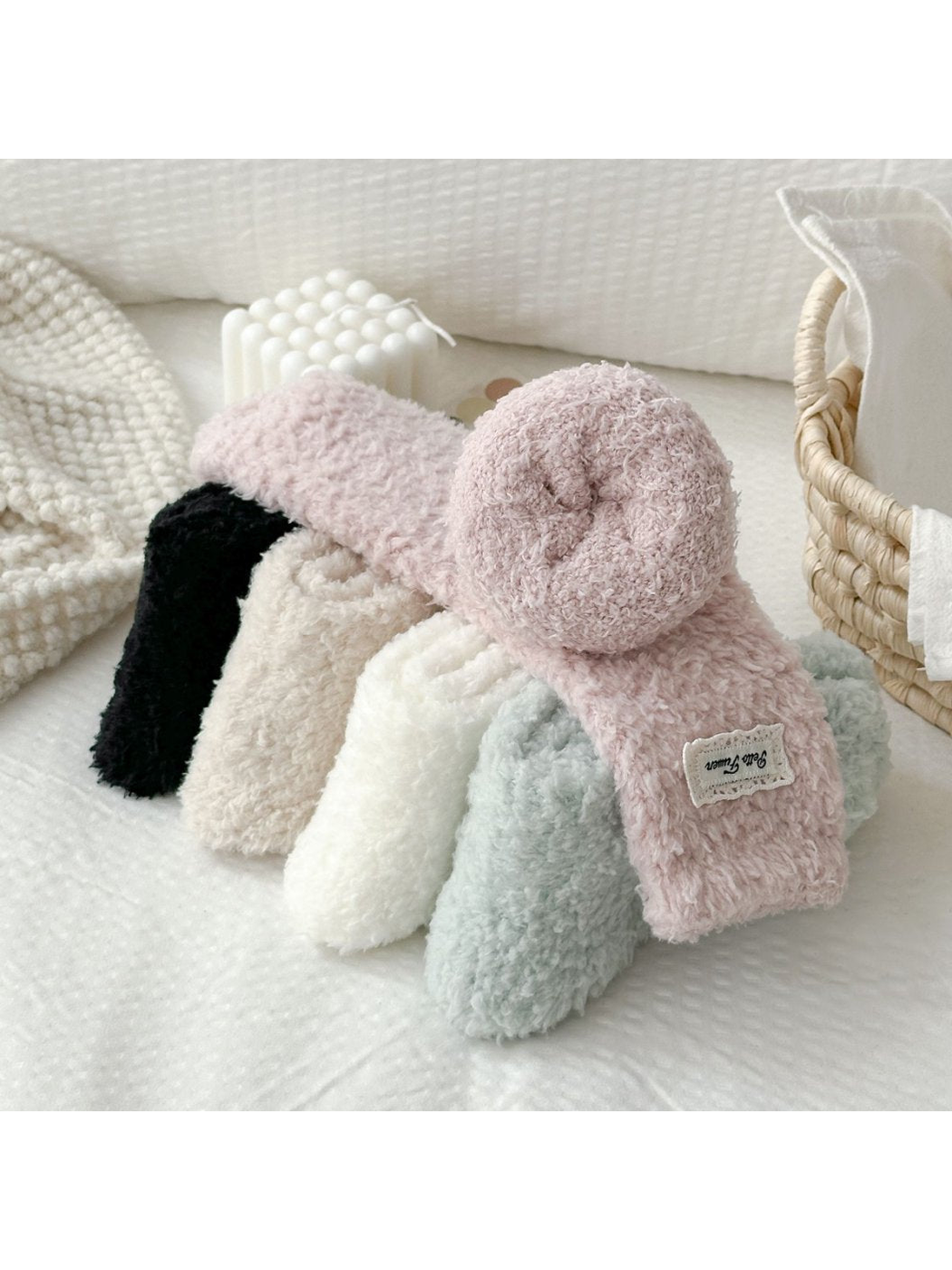 Five fuzzy sock colors arranged with one dusty pink sock rolled at the cuff