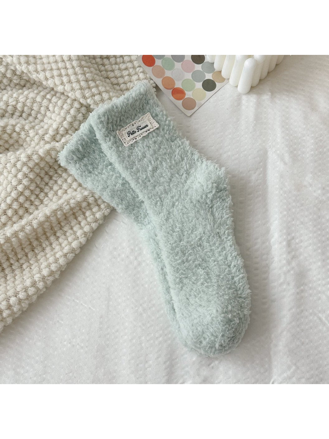 Mint green fuzzy socks with a rectangular label patch