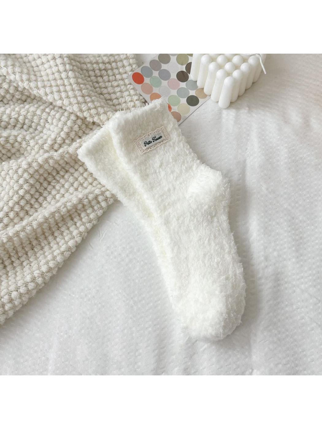 Ivory fuzzy socks with a rectangular label patch