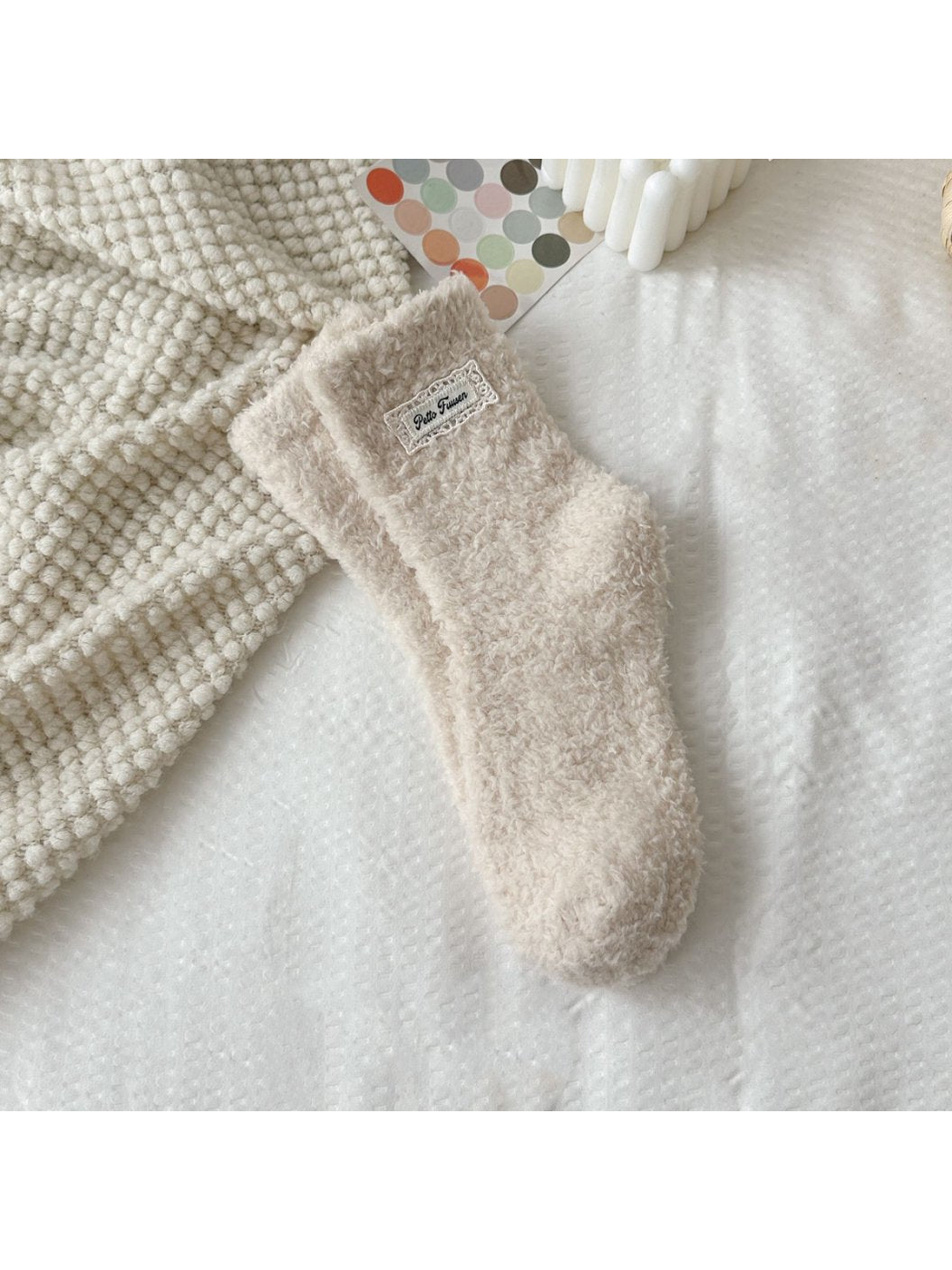 Beige fuzzy socks with a rectangular label patch