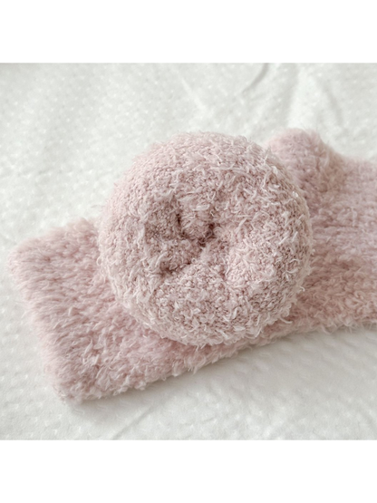 Rolled dusty pink sock showing the cuff interior and fuzzy surface