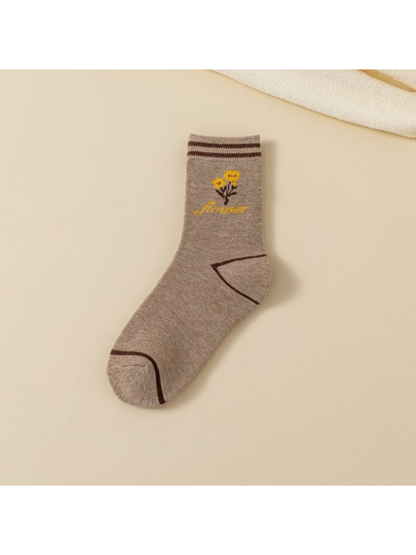 Beige crew sock with cuff stripes, small yellow flower sprig and dark trim