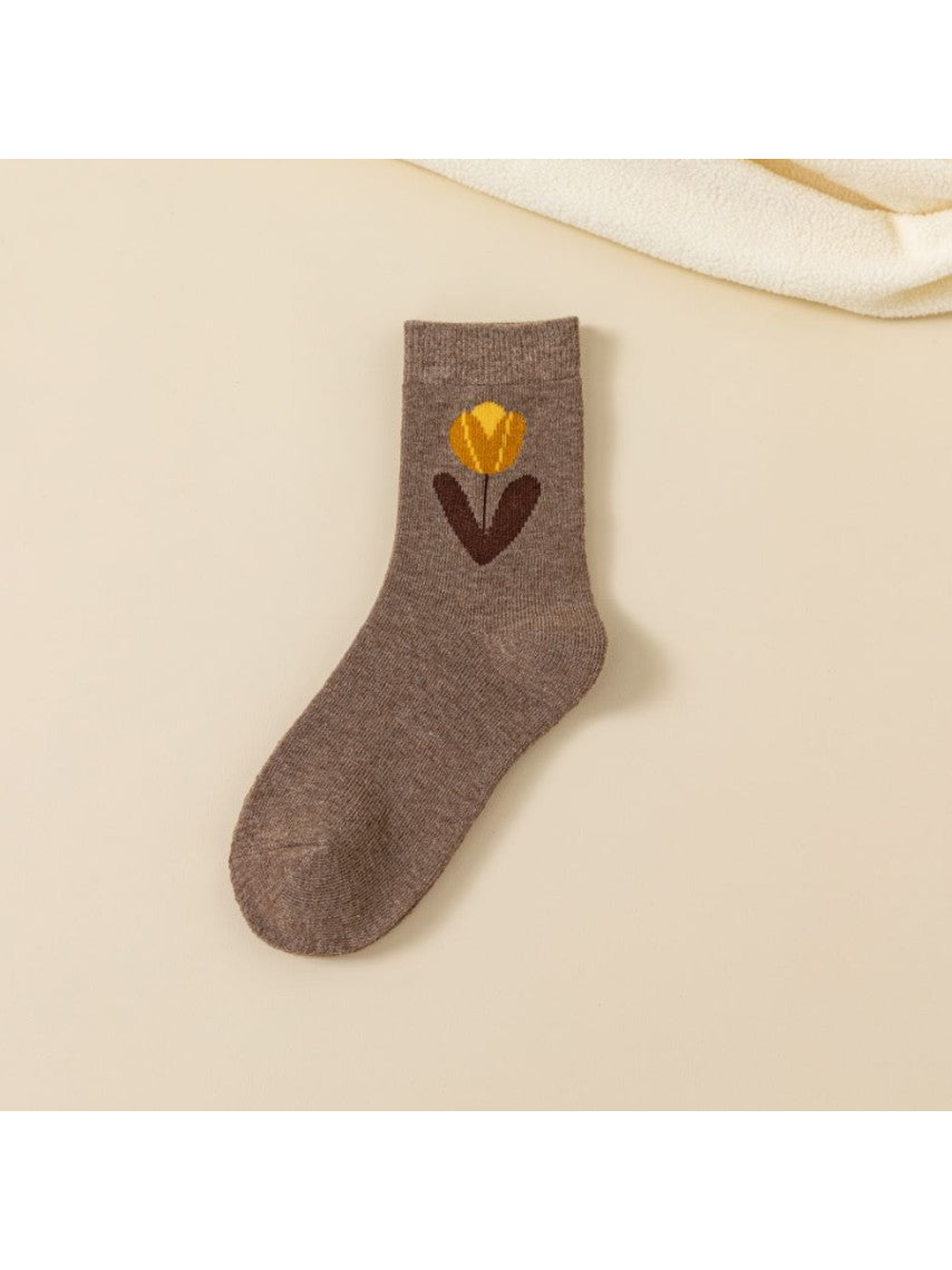 Brown crew sock with a large yellow flower and dark leaves