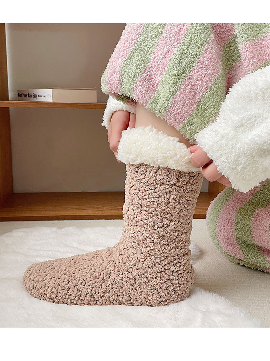 Greige fuzzy crew sock worn with its ivory cuff folded outward