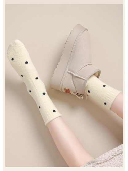 Pale yellow polka-dot crew socks styled with an ankle boot