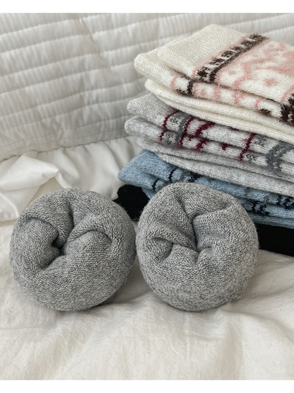 Rolled gray socks with folded patterned color variants in the background