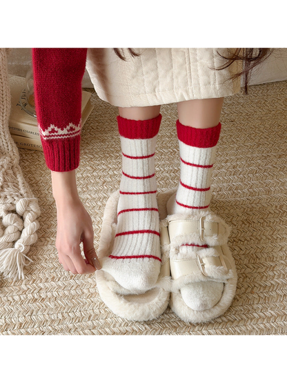 Ivory crew socks with red stripes worn with plush slippers