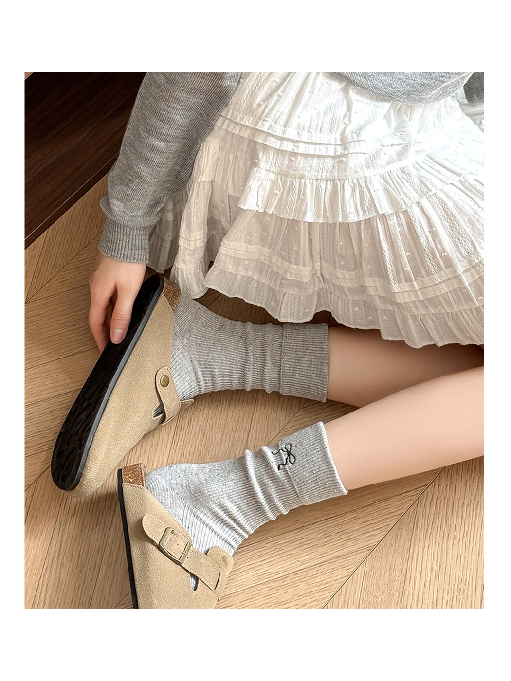 Light gray speckled crew socks styled with beige clogs