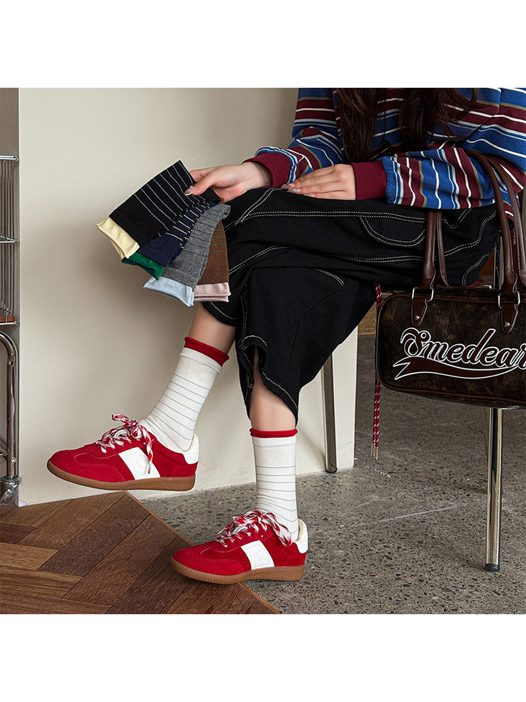 Ivory striped crew socks worn with red sneakers while additional colors are held