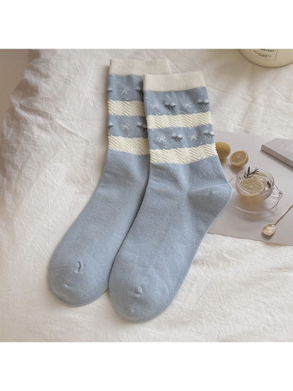 Light blue crew socks with cream textured stripes and small motifs