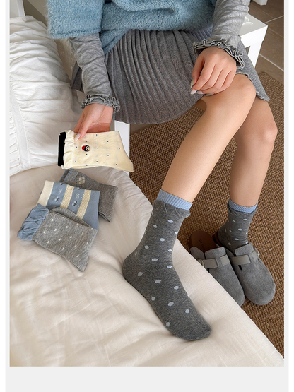 Gray polka-dot crew socks styled with gray clogs beside coordinated sock designs