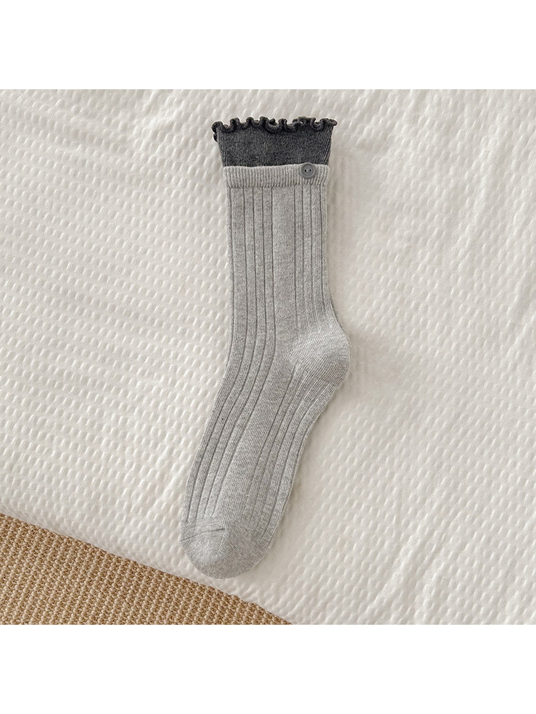 Light gray ribbed crew sock with dark gray ruffle cuff and button accent