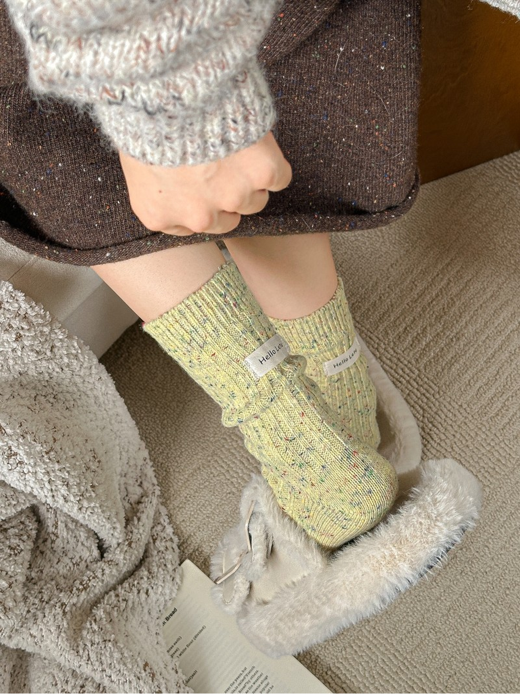 Pale yellow flecked crew socks worn with plush slippers