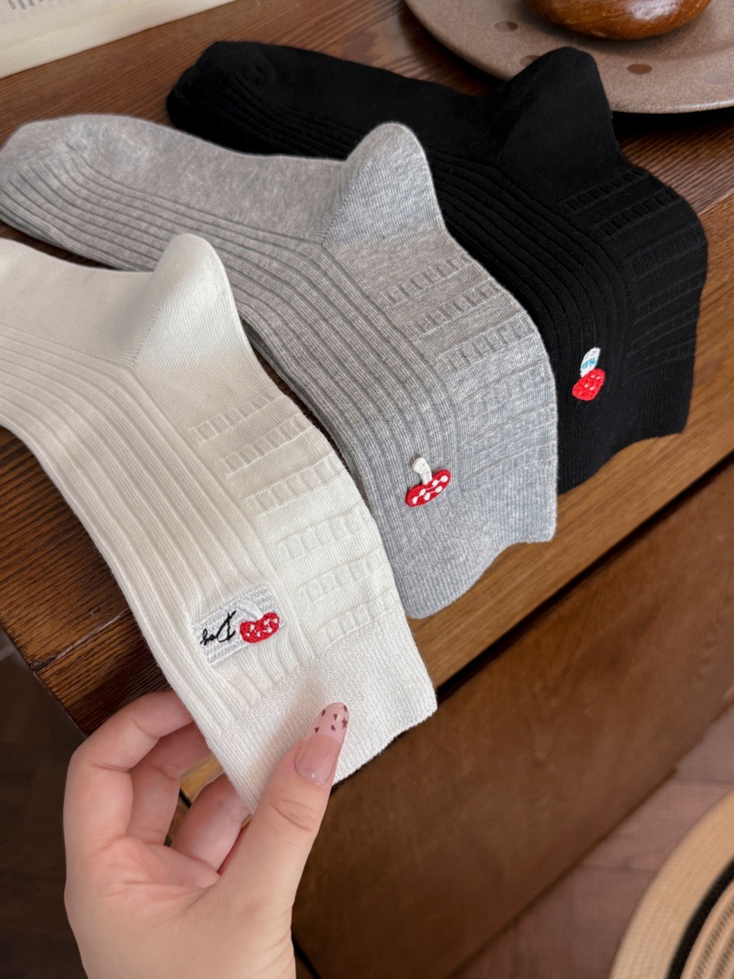 Black, ivory and light gray ribbed crew socks with embroidered mushroom motifs