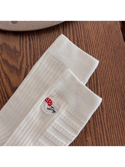 Close-up of the ivory sock ribbing and embroidered mushroom patch