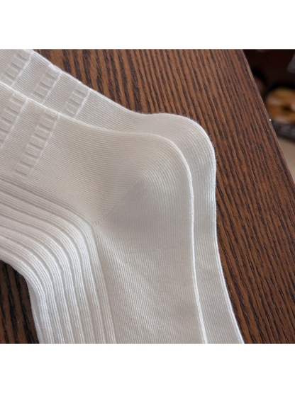 Close-up of the ivory sock's ribbed knit and shaped heel panel