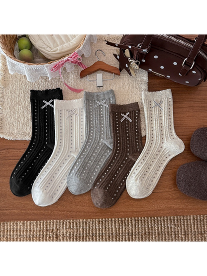 Five colors of dotted ribbed crew socks with ribbon bows displayed together