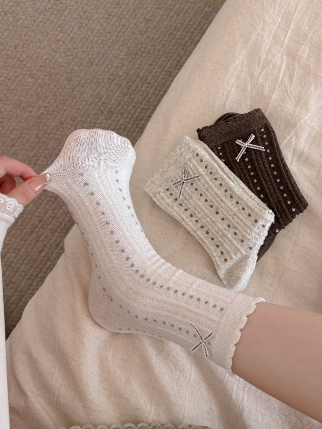 White dotted crew sock stretched at the heel beside beige and brown color options