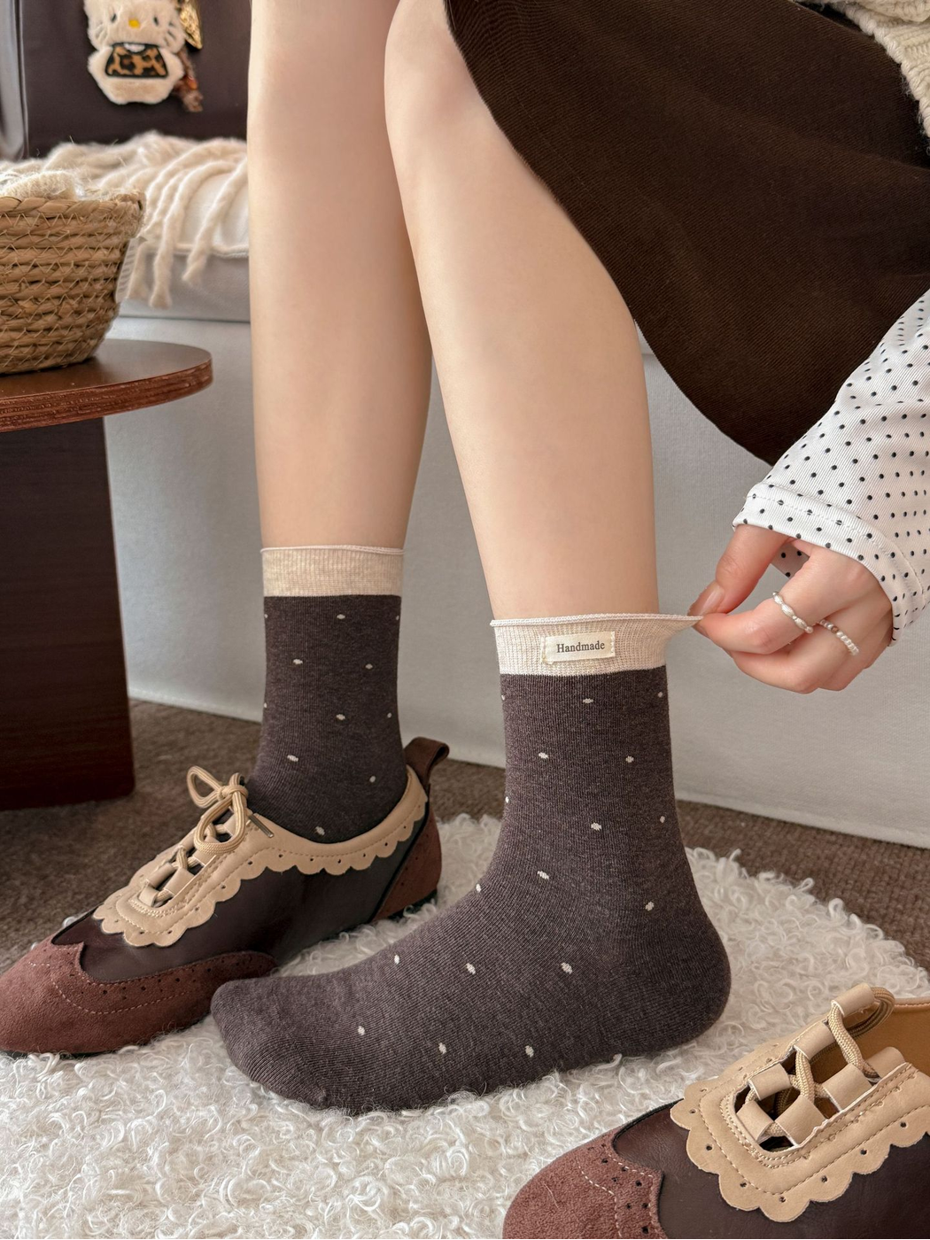 Dark brown polka-dot crew socks worn with brown lace-up shoes