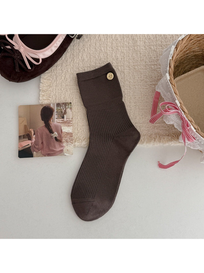 Dark brown crew sock with a ribbed leg and gold-tone button accent, flat lay