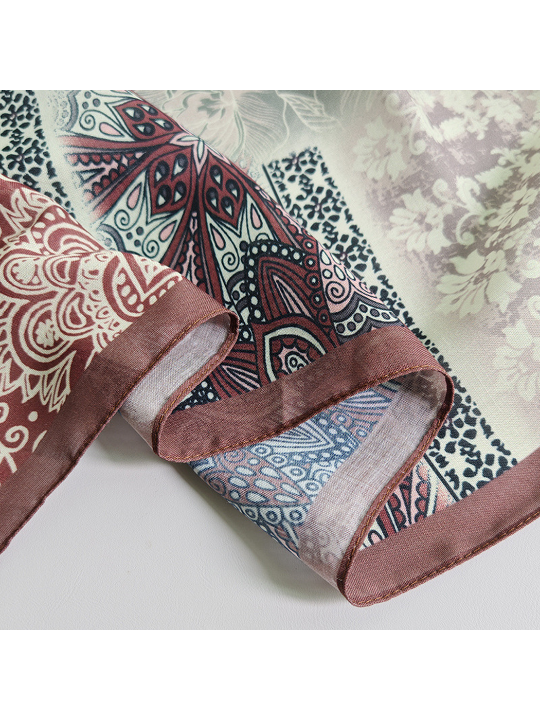 Close-up of the scarf's narrow brown stitched border