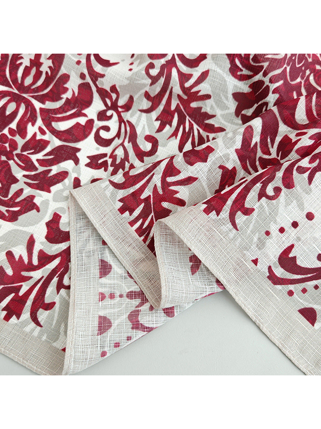 Close-up of the red floral print, crosshatched texture and stitched border