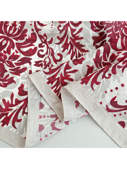 Close-up of the red floral print, crosshatched texture and stitched border