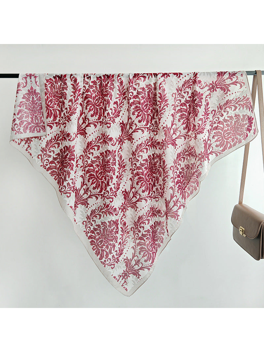 Red and ivory floral square scarf spread across a display rail