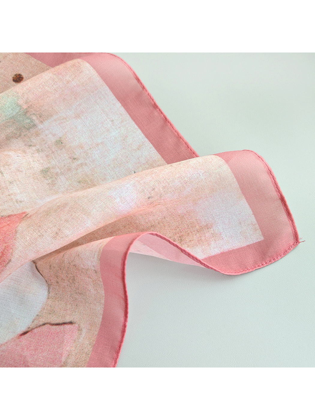 Close-up of the scarf's sheer appearance and stitched pink edge