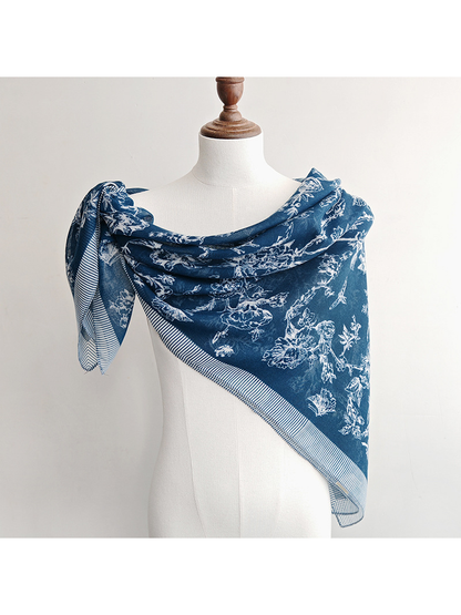 Navy blue patterned scarf draped diagonally across a dress form