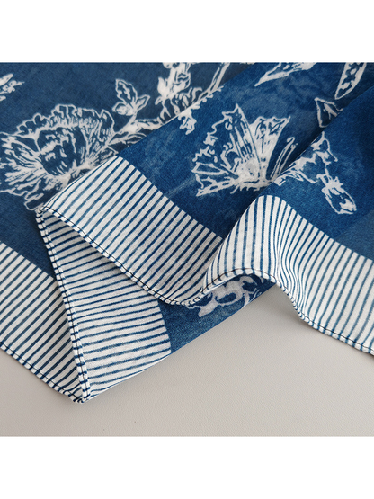 Close-up of the navy blue scarf's stitched striped border and chevron corner