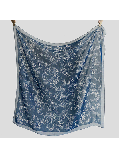 Navy blue square scarf hanging open to show the allover motifs and sheer appearance
