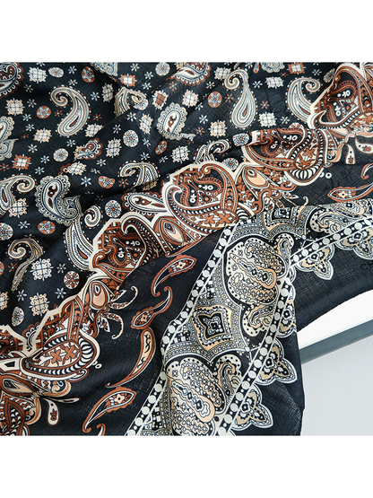 Close-up of rust paisley motifs and the pale ornamental scarf border