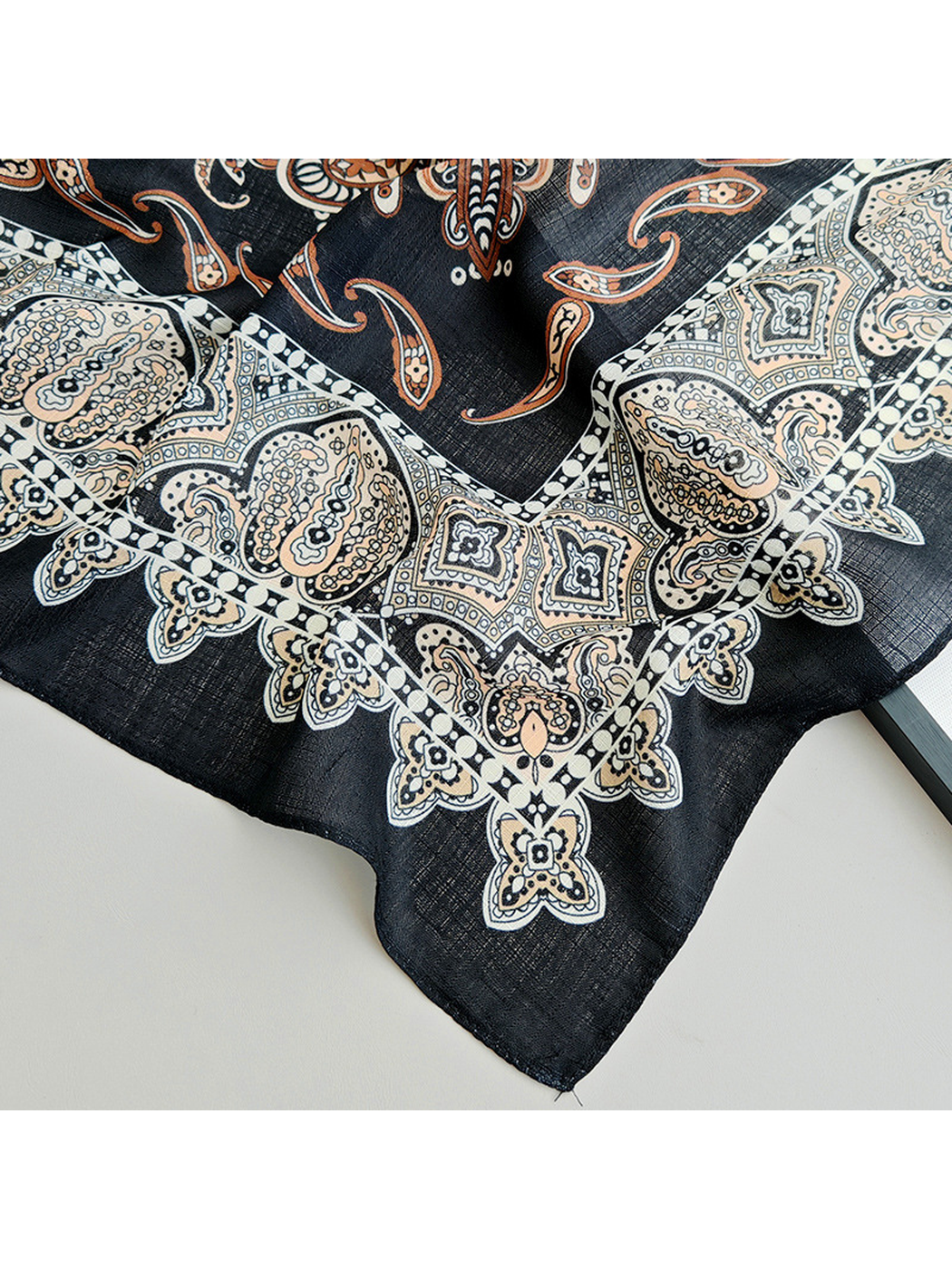 Close-up of the scarf's stitched corner and pale ornamental border